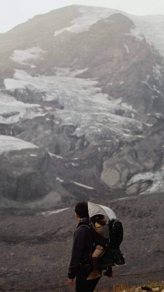On a misty trail below a glacier-draped peak