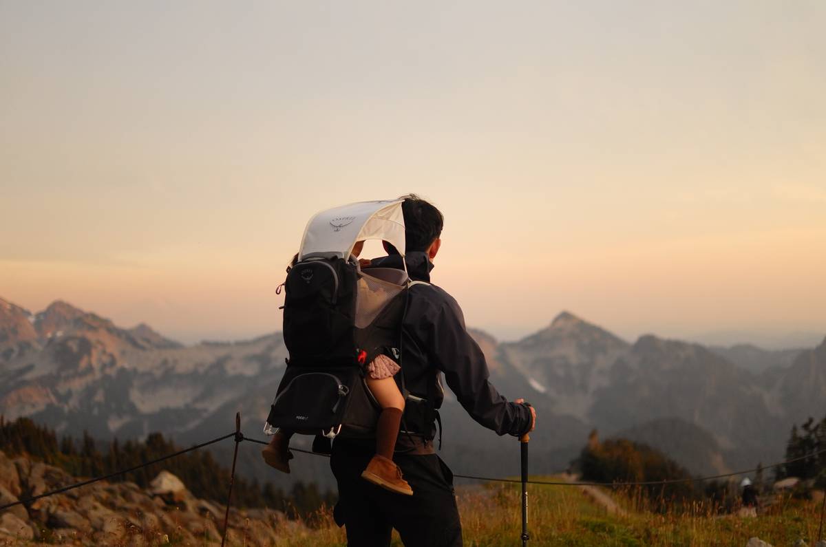 Hiking along a high mountain ridge at sunset, carrying my child